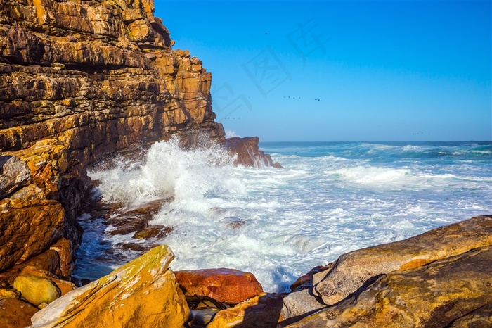 拍打着海岸礁石的海浪摄影高清图