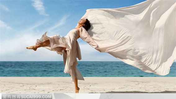 穿白色抹裙飘扬的披肩单脚腾空在沙滩上跨越