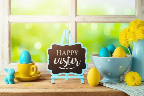 复活节假期的概念与复活节彩蛋和花卉在木制桌子上的窗户背景 复活节假期的概念与复活节彩蛋和花卉在木制桌子上的窗户背景