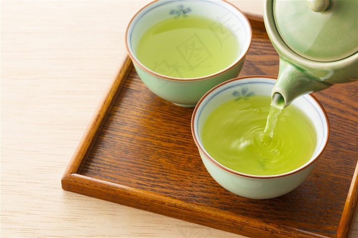 茶壶倒进茶杯的绿茶高清图片