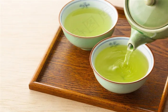 茶壶倒进茶杯的绿茶高清图片