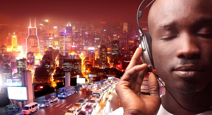 城市夜景上的戴着耳麦享受音乐的男人高清图片