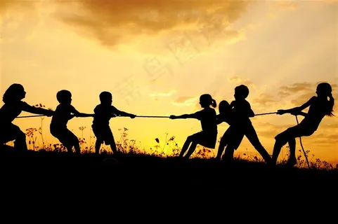 夕阳下拔河的小朋友高清摄影图