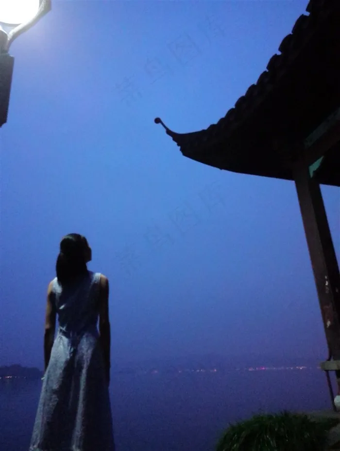 傍晚，西湖边上仰望天空的女子