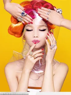 红色染发盘头的女人闭眼和带着不同另类戒指的手图片素材