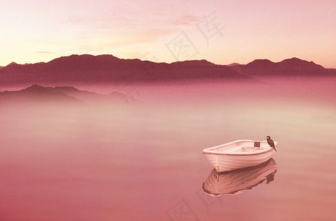 夕阳染红的水面上的帆船