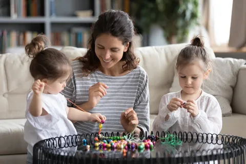 亲子互动母亲陪伴双胞胎女儿做串珠 亲子互动母亲陪伴双胞胎女儿做串珠