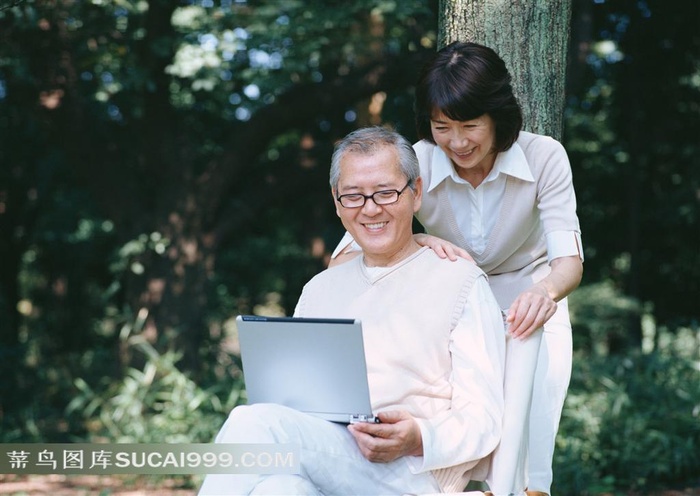 树下上网的甜美幸福夫妻