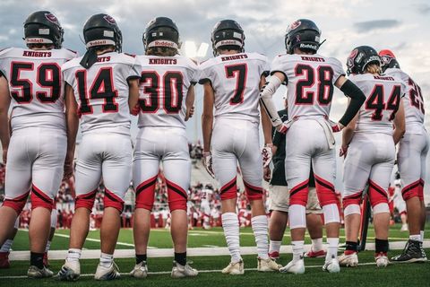 草地上的足球运动员背影图片