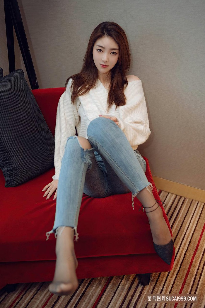 坐在红色沙发上的牛仔裤美女可樂高清图片