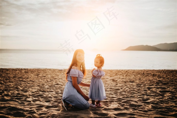 夕阳下沙滩上大海边亲子装母女图片