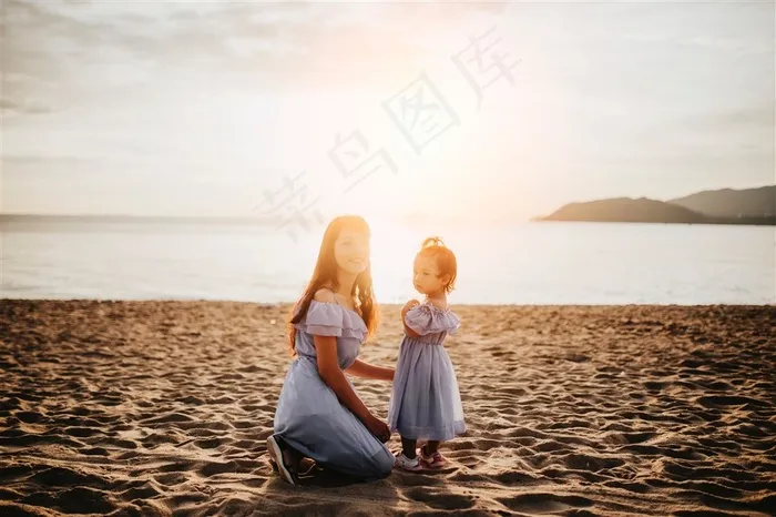 夕阳下沙滩上大海边亲子装母女图片