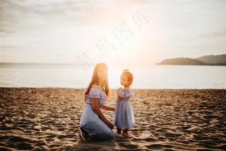 夕阳下沙滩上大海边亲子装母女图片