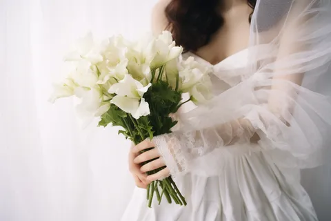 新娘穿着白色婚纱拿着白色手捧花摄影图