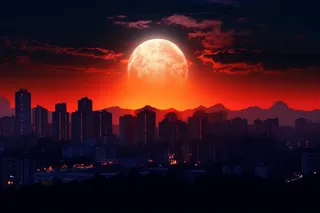 月圆之日夜晚城市上空的月亮摄影图