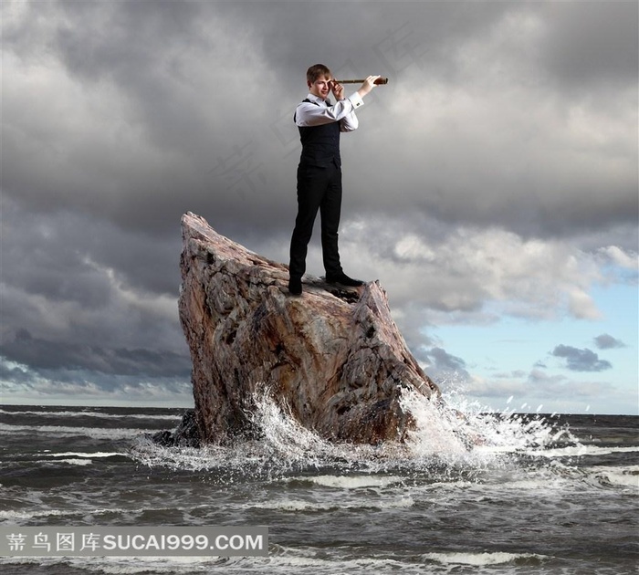 礁石上拿着望远镜的商务人士