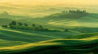 春日阳光下绿色连绵山脉草坪