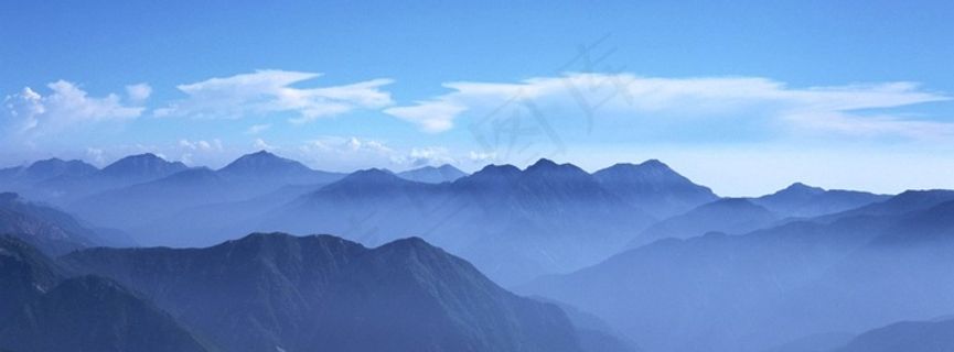 蓝天白云下云雾缭绕的山脉