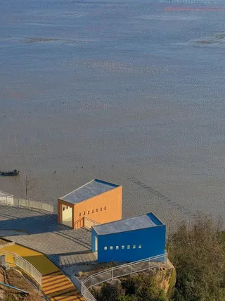 夕阳下海边的橙色房子和蓝色房子