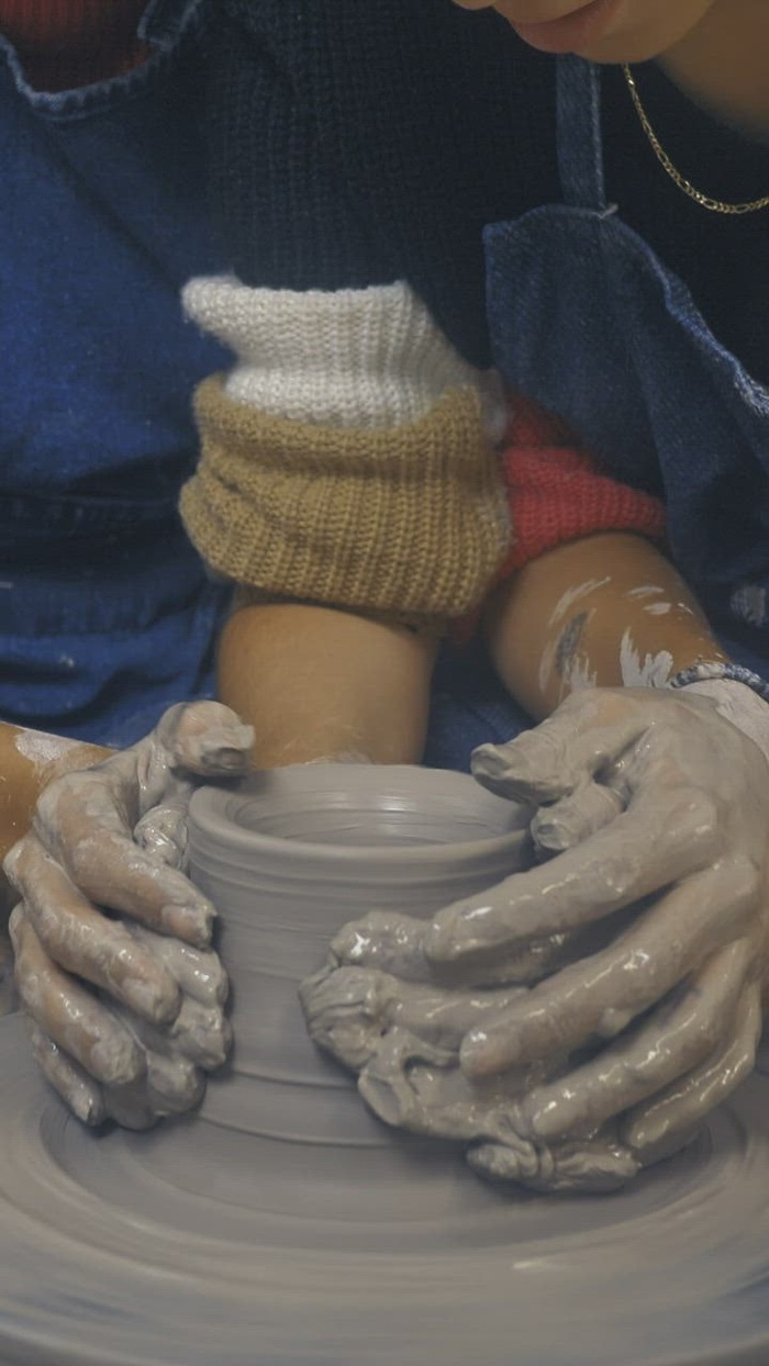 夫妇一起制作粘土花瓶的女孩