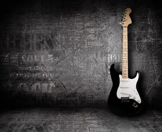 黑色墙角里的吉他高清摄影图片