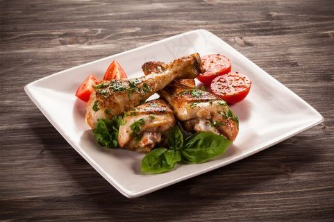 木桌上的一盘烤鸡腿