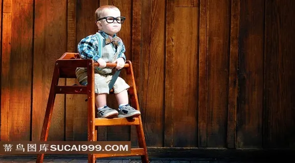 坐在高脚凳子上戴眼镜的小小外国“科学家”