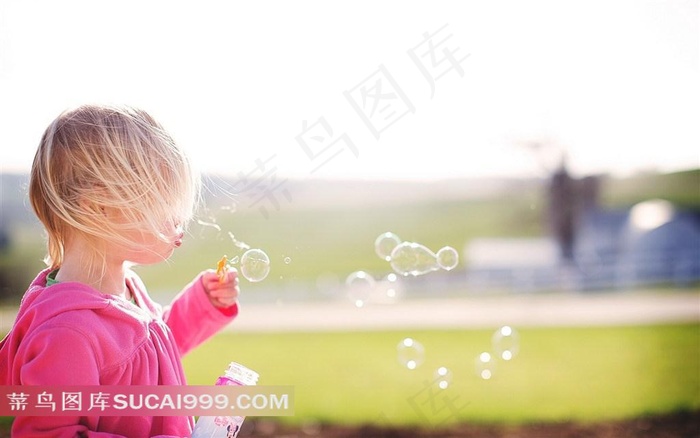 阳光里吹泡泡的小女孩