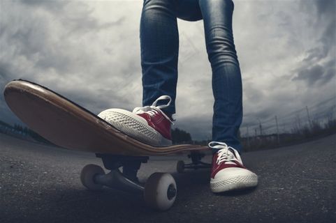 在马路玩滑板的男性