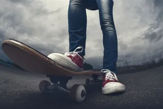 在马路玩滑板的男性