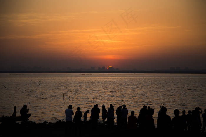 夕阳下海滩人群剪影图片