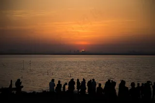 夕阳下海滩人群剪影图片