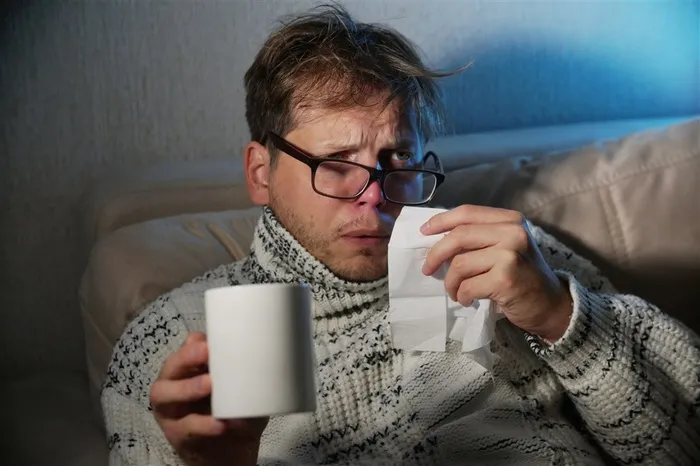 手拿杯子想要擦鼻涕的男子高清摄影