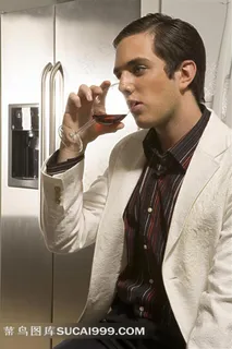 在冰箱旁边和红酒的外国男人