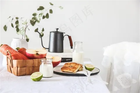 温馨家居餐桌上的胡萝卜苹果柠檬蔬菜水果蛋糕饼干牛奶