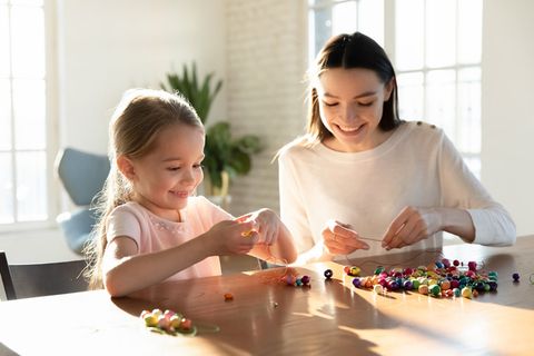 亲子互动母亲陪伴女儿做串珠