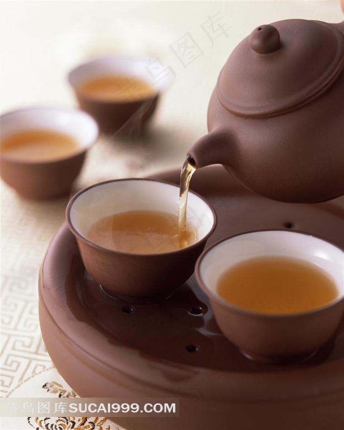往茶碗里倒水的紫砂壶
