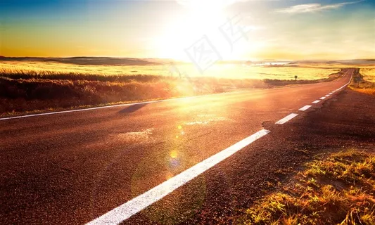 阳光下草地中的马路高清摄影图
