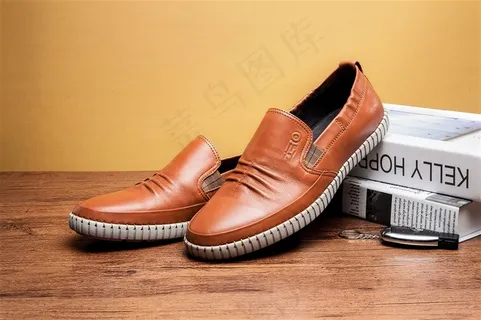 台子上木板旁的黑色男士皮鞋图片欣赏