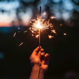 夜晚手拿着点燃的烟花仙女棒闪光摄影图