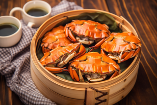 餐桌蒸笼屉里的螃蟹和茶壶摄影图