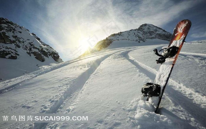 插在雪坡上的滑雪板和阳光山峰