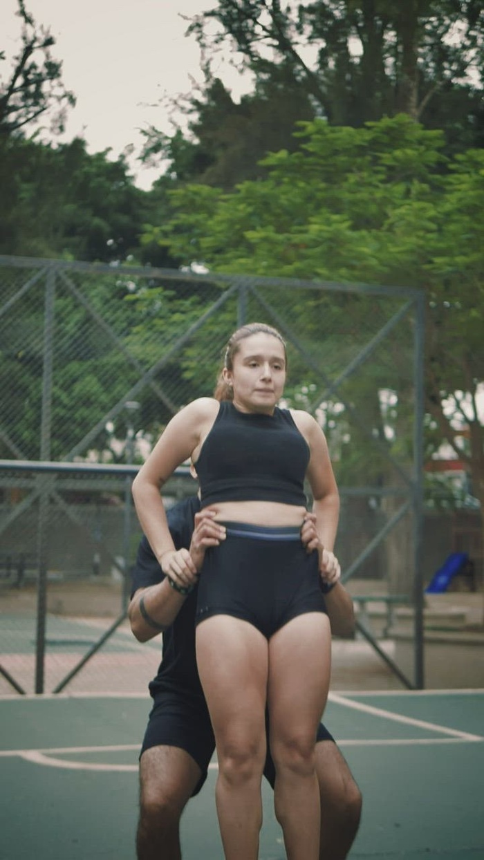 啦啦队长男孩在他的手上举起一个女孩