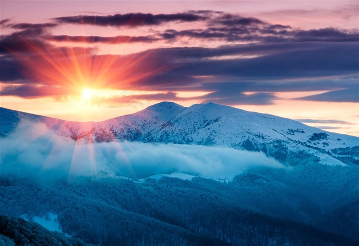 清晨升起的雪山顶上的太阳高清素材图片