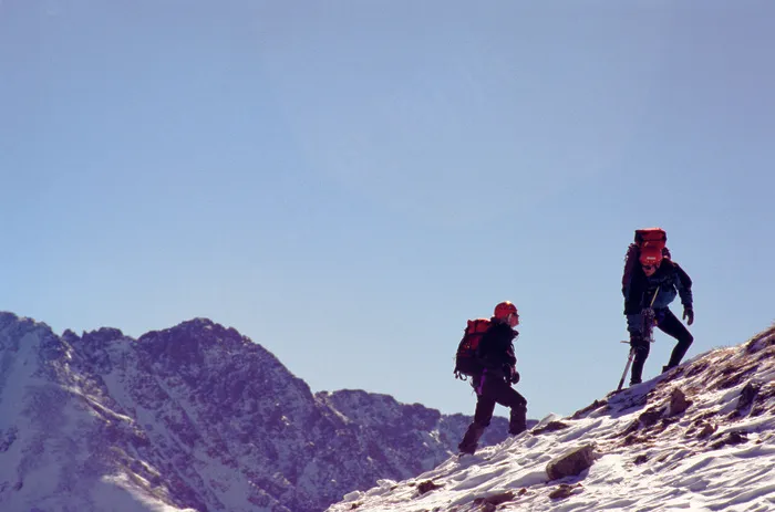 攀登雪山高峰的两个人图片