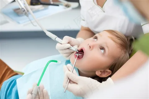 拿着医疗器械给小孩子做口腔治疗的医生高清图片 拿着医疗器械给小孩子做口腔治疗的医生高清图片