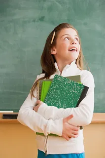 室内抱着书本的小女孩图片