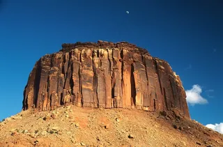 蓝天下土坡上的石峰石壁