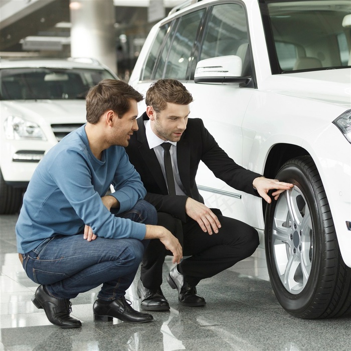 为客人讲解汽车的销售男人