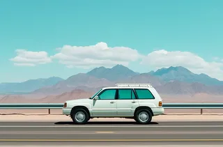 白色汽车在高速公路上行驶旁边是远处的雪山摄影图